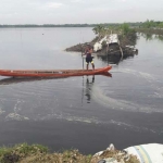 Salah satu petani sedang naik perahu di titik jebolnya tanggul kali apur ingas di Kecamatan Kanor, Bojonegoro. Petani itu belum mengikutkan sawahnya asuransi pertanian. foto: EKY NURHADI/ BANGSAONLINE