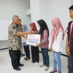 Senior CSR Officer Semen Indonesia Pabrik Tuban, Setiawan Prasetyo saat menyerahkan beasiswa.