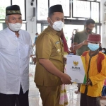 Bupati Gresik Fandi Akhmad Yani ketika menyerahkan santunan untuk anak yatim. foto: SYUHUD/ BANGSAONLINE