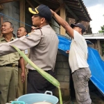 Petugas BPBD bersama Polres Blitar Kota melakukan kerja bakti di lokasi terdampak dengan memasang terpal agar tanah tidak semakin tergerus.