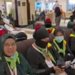 Jemaah haji asal Lamongan mengenakan mawar di kerudung sebagai penanda agar tidak terpisah dari rombongan