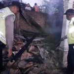 Petugas sedang melihat puing-puing rumah korban.