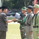 Bupati Tuban menyerahkan cangkul kepada prajurit TNI sebagai tanda dibukanya TMMD ke-104.