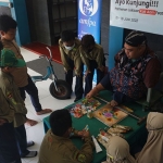 Pelukis difabel, Aam, saat menunjukkan kepiawaiannya melukis dengan kaki di kanvas. Foto: SYUHUD/BANGSAONLINE