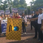 Kapolres (kaos putih) bersama Bupati Rendra saat mengibarkan bendera start.