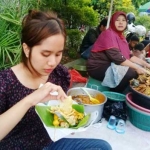 Seorang pemburu kuliner menikmati nasi boran khas Lamongan. (foto: ist)