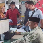 Tersangka Sut (peci hitam), saat dijemput Tim Saber Pungli yang terdiri dari Kasi Pidsus Kejari dan Tipikor Polres Jember di kantor Disperindag Jember.