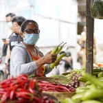 Seorang warga sedang berbelanja di pasar. Foto: Ist. 