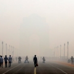 Orang-orang berjalan di depan kabut asap menutupi peringatan perang Gerbang India di Delhi, India.