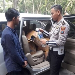 Kanit Turjawali Satlantas Polres Ngawi saat mengecek miras. foto: ZAINAL ABIDIN/ BANGSAONLINE