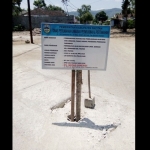 Warga menutup dengan papan nama proyek di atas betonan yang bolong.