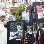 Khofifah mengagumi kaos bergambar Proklamator Kemerdekaan RI, Soekarno yang dijual PKL di pasar tumpah Indrapura, Surabaya. foto: ist