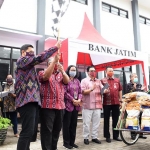 Wali Kota Kota Kediri, Abdullah Abu Bakar dan Direktur Kepatuhan dan Manajemen Risiko Bank Jatim, Erdianto Sigit memberangkan becak pengangkut bantuan sembako, disaksikan oleh Ketua TP PKK Kota Kediri Ferry Silviana Abu Bakar. (foto: ist)