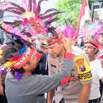 Ika dan Vina mendapatkan kehormatan memasangkan ikat kepala khas Papua dari bulu burung Cendrawasih ke Kapolresta Sidoarjo, Senin (26/8/2019) sore.