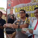 Kapolres Blitar Kota AKBP Adewira Negara Siregar menunjukkan barang bukti uang palsu pecahan 100 ribu.