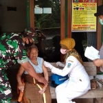 Petugas Bhabinkamtibmas Polres Nganjuk saat meninjau penyuntikkan vaksin Covid-19 pada lansia.