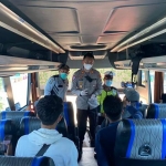 Kasatlantas Polres Bangkalan AKP Abdul Aziz Sholahuddin saat memeriksa penumpang bus terkait kelengkapan surat bebas Covid-19 serta prokes di Terminal Bangkalan, Senin (14/6/2021).