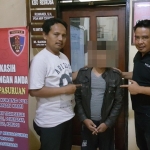 Tersangka saat bersama petugas Satreskrim Polres Pasuruan. 