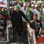 Pasangan calon Ra Hamid-Ra Fadil (naik becak) bersama ratusan pendukungnya saat mendaftar di KPU. (hadi prayitno/BANGSAONLINE)