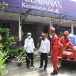 Camat Gresik Purwanto bersama tim dari Petrokimia Gresik saat penyemprotan disinfektan di lingkungan Kantor Kecamatan. foto: ist