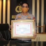 Kapolres Ngawi saat menunjukkan penghargaannya dari Kapolri kepada BANGSAONLINE.com.