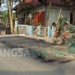 Aparat TNI dari Koramil 0810/13 Lengkong bersama warga memperbaiki jalan berlubang di Dusun Duwel, Desa Jegreg, Kecamatan Lengkong . foto: BAMBANG DJ/ BANGSAONLINE