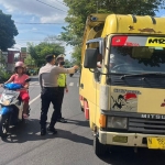 Petugas dari Polres Batu saat memantau lalu lintar mobil ternak.