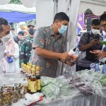 Kepala KPwBI Kediri Choirur Rofiq (kiri) dan Wali Kota Kediri Abdullah Abu Bakar saat menyambangi dan membeli produk UMKM di salah satu stand. foto: ist.