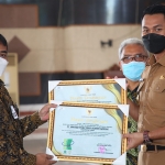 Bupati Tuban Aditya Halindra Faridzky menyerahkan penghargaan Zero Accident dari Gubernur Jawa Timur kepada Corporate SHE, SR, Security & Communication Departement Head UTSG, Budi Banyuarsyah.