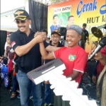 Pembina Orari, Gus Syaf, saat menyerahkan hadiah utama berupa sepeda motor kepada salah satu warga yang beruntung.