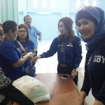 Ketua Panpel Pasar Murah Partai Demokrat, Sri Subiati (kanan berkerudung) mengawasi pembagian paket sembako. 