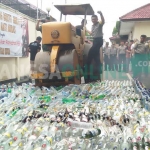 Alat berat yang digunakan untuk memusnahkan ribuan botol miras. foto: AKINA/ BANGSAONLINE