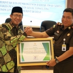 Bupati Tuban Fathul Huda saat menyerahkan penghargaan kepada Kajari Tuban Bambang Dwi.