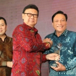 Bupati Gresik Sambari HR saat menerima penghargaan dari Mendagri RI Tjahjo Kumolo. foto: SYUHUD/ BANGSAONLINE