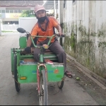Catur Prabusono saat berkeliling menjajakan rotinya memakai sepeda roda tiga yang dimodifikasi.
