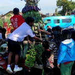 Panitia saat membagikan sayur dan buah-buahan kepada warga. (Ist). 
