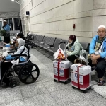 Isrudin (kanan) duduk bersama ibunya dan mendampingi tiga jemaah lansia. Foto: MCH 2026.