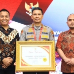 Kapolresta Malang Kota Kombespol Budi Hermanto menunjukkan piagam penghargaan kategori pelayanan prima dan predikat pembangunan ZI.