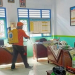 Petugas menyemprotkan disinfektan sebagai persiapan menjelang pelaksanaan KBM tatap muka.