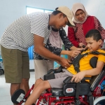 Sekretaris Dinsos Kabupaten Kediri Dyah Saktiana saat menyerahkan kursi roda kepada salah satu penyandang disabilitas. Foto: Ist.