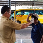 Petugas kesehatan melakukan screening di terminal Pakusari Jember. 