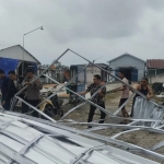 Anggota Polsek Sukodadi bergotong royong bersama warga saat membersihkan puing kanopi yang ambruk diterjang puting beliung