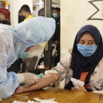 Petugas medis saat mengambil sampel darah salah satu pengunjung cafe untuk dilakukan rapid test. foto: ist.