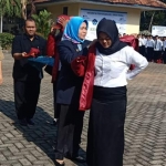 Rektor Unirow Tuban Dr. Supiana Dian Nurtjahyani, M.Kes memakaikan jas almamater pertanda kegiatan KKN dimulai.