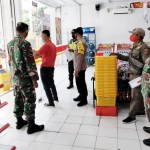 Petugas gabungan sedang melakukan sosialisasi di salah satu toko swalayan.