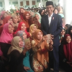 Presiden Jokowi ketika diajak swafoto oleh ibu-ibu yang hadir di Ponpes Amanatul Ummah.