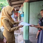 Petugas Dispendukcapil Kota Kediri saat menyerahkan akta Kematian secara door to door. Foto: Ist