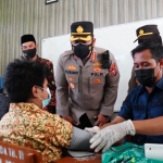 Kapolresta Sidoarjo Kombes Pol. Kusumo Wahyu Bintoro saat menyapa salah satu siswa yang divaksin.