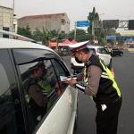 Petugas memeriksa salah satu kendaraan di salah satu exit tol.