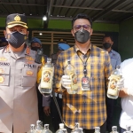 Kapolresta Sidoarjo, Kombes Pol Kusumo Wahyu Bintoro, saat menunjukkan barang bukti berupa miras oplosan yang disita dari sebuah kontrakan di Desa Mojoruntut, Kecamatan Krembung.